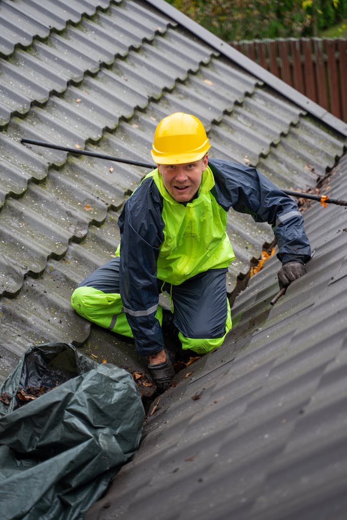 Construction worker on a rooftop ensuring safety with helmet and gear.